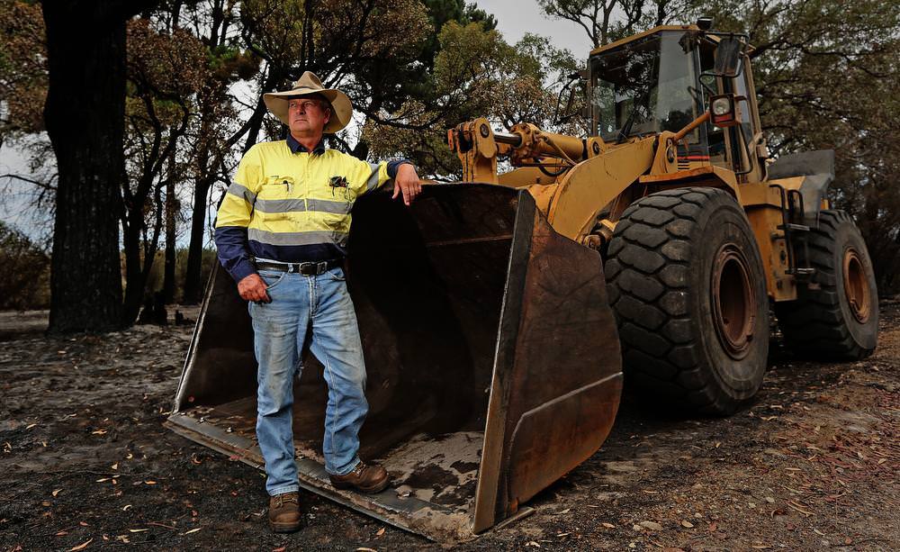Waroona Farmer Peter Stacey with the damaged front end loader that he used to fight the fire along Coronation Rd. Picture: Michael Wilson, The West Australian.